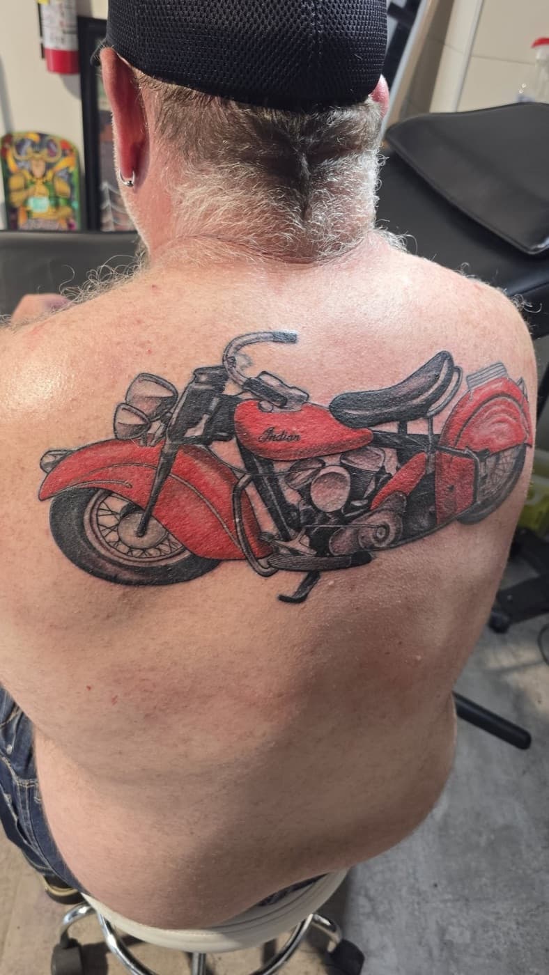 Red vintage motorcycle rendered across an upper back