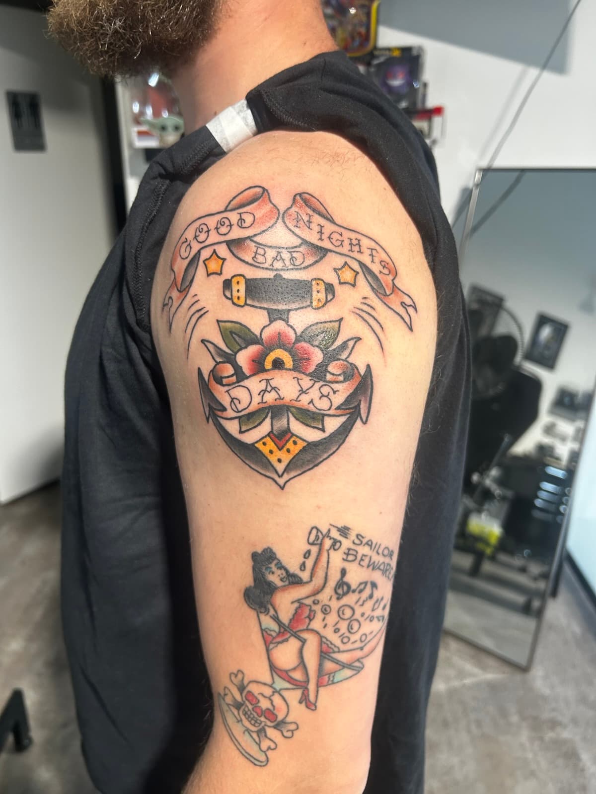 Anchor with a flower and banners reading 'Good Nights, Bad Days', colour on the upper arm