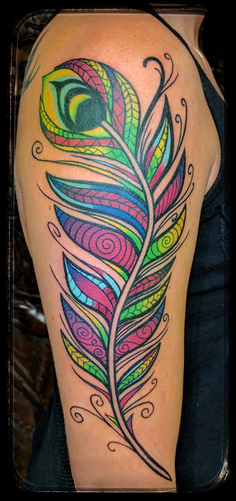 Peacock feather filled with spirals and patterns, bright colour on the outer upper arm